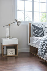 modern lamp on bedside table with wooden bed