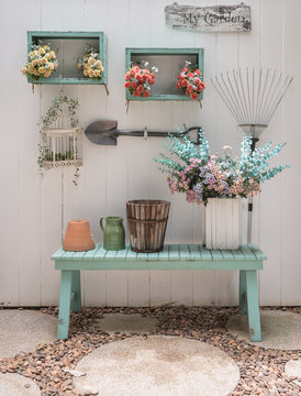 Flower On Green Bench With White Wood Panel Wall