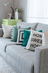 modern grey sofa with black and white and green pillows
