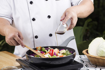 Chef pouring sauce to the pan
