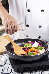 Chef pouring soup to the pan