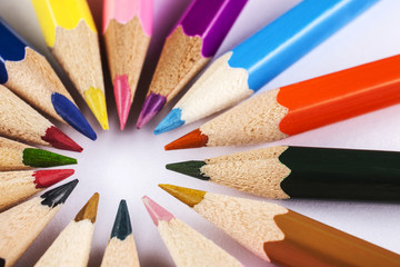 coloring pencils in a circle centered to the left top view close-up shot on a white background