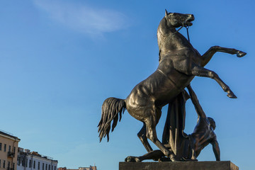 Fototapeta na wymiar Anichkov bridge and sculpture tamer of horses, Saint Petersburg Russia