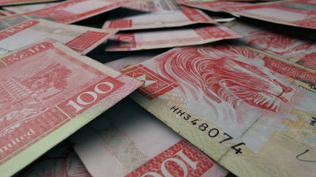 An extreme close up pan of a pile of randomly scattered hong kong dollar banknotes