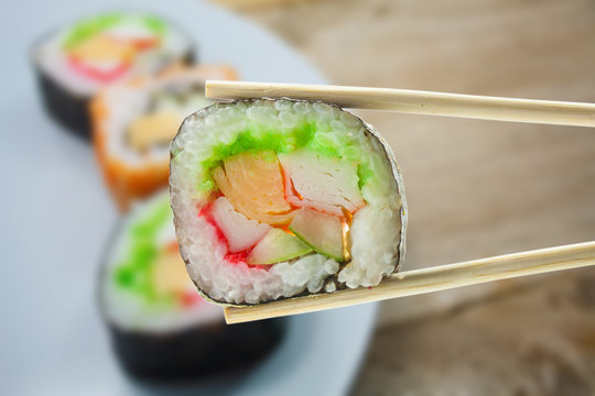 sushi maki in chopsticks