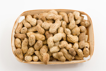 wooden container is filled with a peanut on a white background