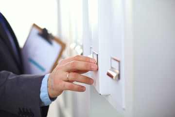 File folders, standing on  shelves in the background