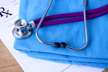 A stethoscope shaping a heart and a clipboard on a medical uniform, closeup