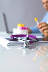 Doctor at work, close up of male doctor typing on a laptop