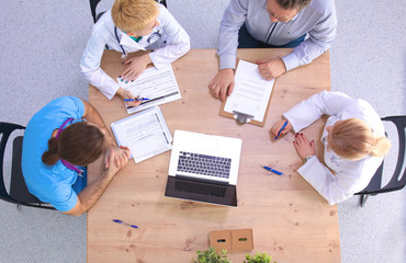 Male and female doctors working on reports in medical office