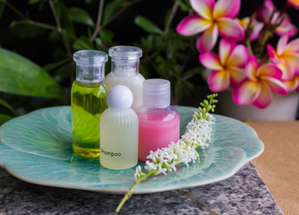 Mini set of bubble bath and shower gel decorated with beautiful flower and plant background for relaxation corner in bathroom