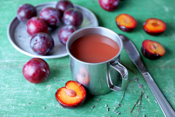 Delicious plum juice with fruits on wooden table close up