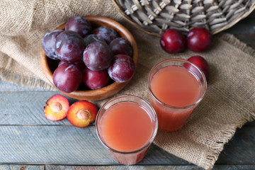 Delicious plum juice with fruits on wooden table close up
