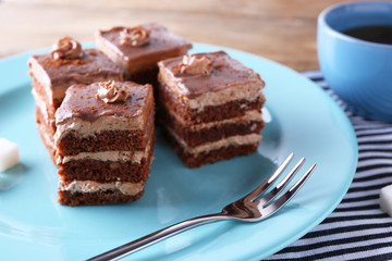 Sweet chocolate cake on blue plate on wooden table