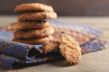 Cookies with chocolate crumbs on ornament napkin against blurred background, close up