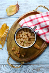 Mug of soup on metal tray on a table