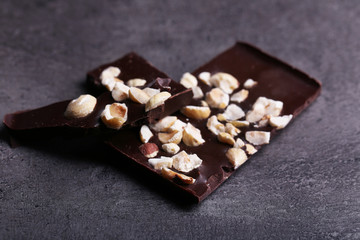 Black chocolate pieces and nuts on dark gray background