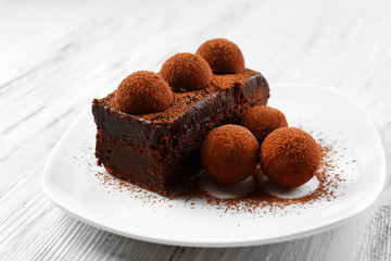 Slice of chocolate cake with a truffle on plate closeup