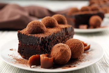 Slices of chocolate cake with a truffle on plate closeup