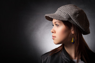Portrait of a young girl in a cap and a profile.