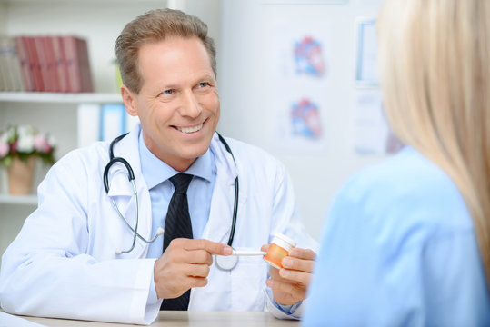 Smiling cardiologist talking to the patient 