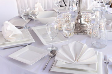 Table served with white square plates and wineglasses