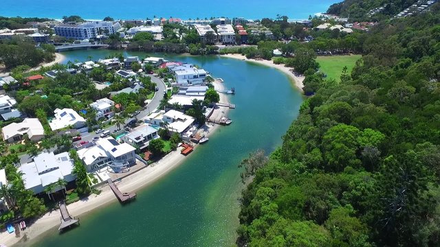 Aerial footage views of Queensland Tourism hot spot Noosa Heads and Noosa River, with clean blue pristine tropical water. Featuring boats, moorings, wetlands, sandbars, tourists and holiday makers.