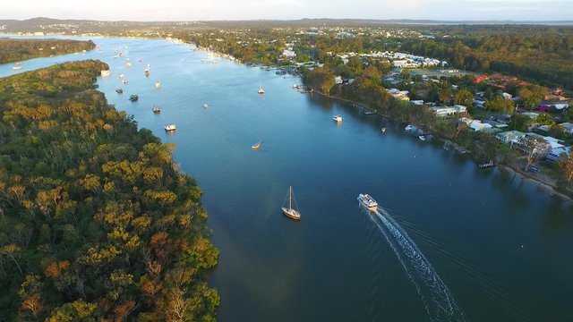 Aerial footage views of Noosa River, with clean blue pristine tropical water. Featuring boats, moorings, wetlands, sandbars, tourists and holiday makers.
