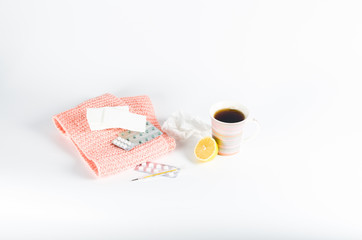 Hot tea for colds, pills and handkerchiefs on white background