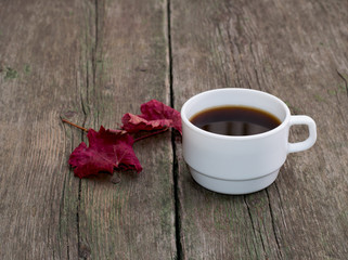 still life, coffee and brightly red leaf on a wooden table, fall