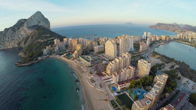 Aerial view of Calpe, Costa Blanca during the day. Popular summer resort in Spain with mediterranean sea and Las Salinas lake, mountains at the background, skyscrapers - hotels, apartments.