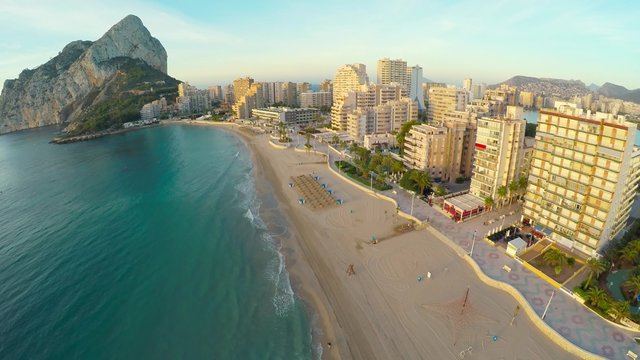 Aerial view of Calpe, Costa Blanca during the day. Popular summer resort in Spain with mediterranean sea and Las Salinas lake, mountains at the background, skyscrapers - hotels, apartments.