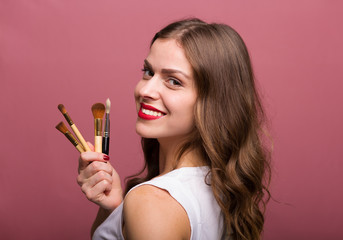 Beautiful woman with cosmetic brush