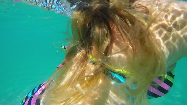 Underwater video of Caucasian woman with long hair waving in the water