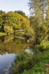 White painted wooden bridge reflected in a small river