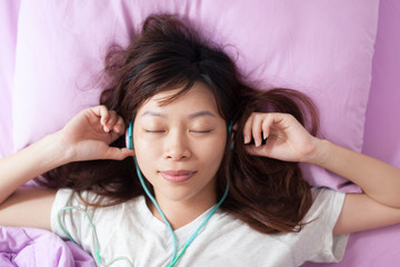 Fototapeta premium Asian young girl listen to music closed eyes wear headphones