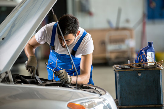 Auto Mechanic Working Under The Hood