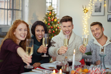 lachende freunde trinken sekt beim weihnachtsessen