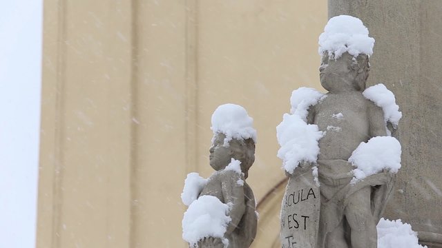 statues of angels outside the church, are ridiculous caps of snow, snowing