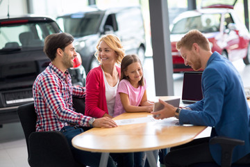 Car salesperson demonstrating new car to family