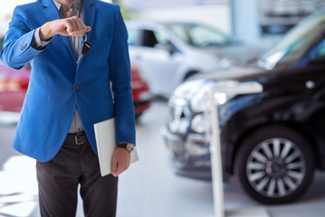 car agent  holding car key in front of him