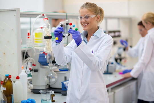 Cheerful chemist hold molecular model in lab