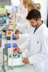 Chemical technicians work with test tubes in lab