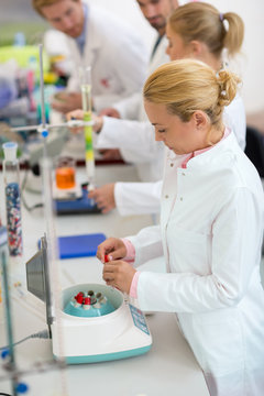 Young chemical technicians work with test tubes in lab