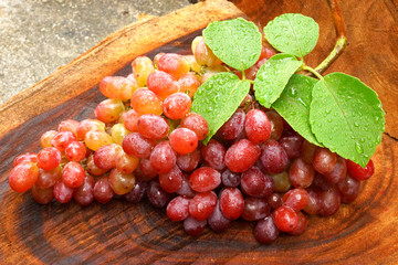 Fresh red grapes on brown wood.