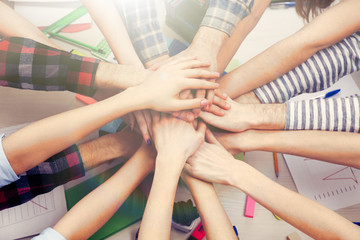 United hands of business team on workspace background top view