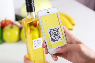 Woman scanning voucher code with mobile phone close up