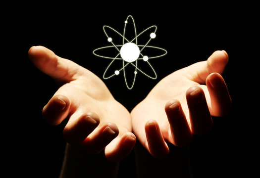 Hands with atom image, on black background