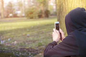 teenage boy taking photographs with a smart phone