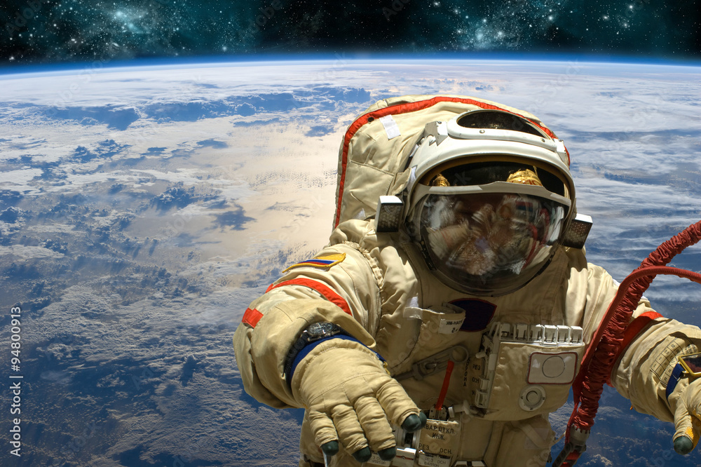 Wall mural a cosmonaut floats in space. - elements of this image furnished by nasa.